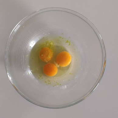 Mettiamo le uova nella ciotola con la buccia del limone grattugiata
